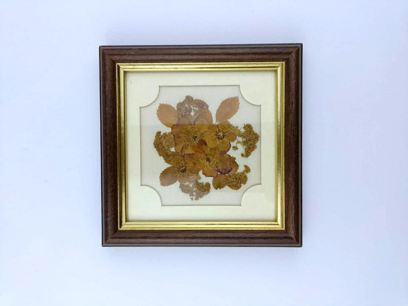 Vintage framed wall picture with glass panel and pressed dried flowers in gold-brown