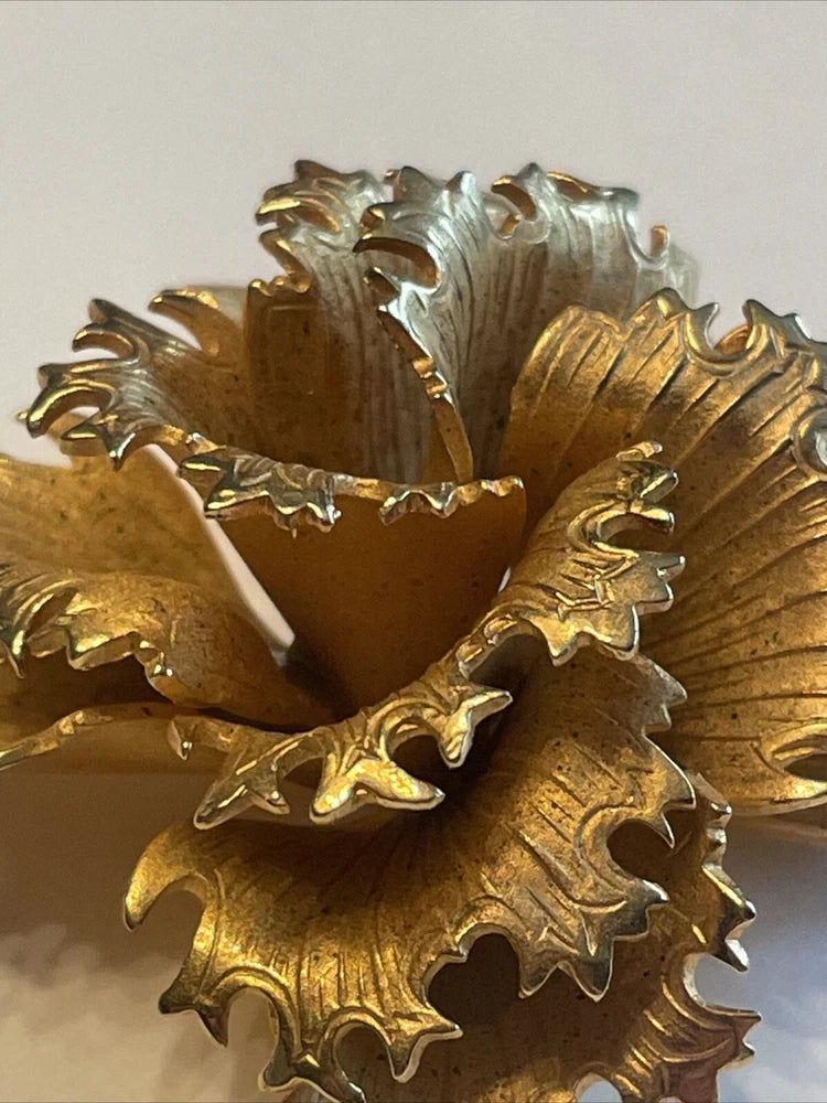 Gold-tone carnation flower brooch with textured petal details and pin clasp