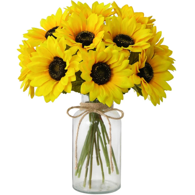 Artificial sunflower flowers with dark centers in clear glass vase, tied with twine