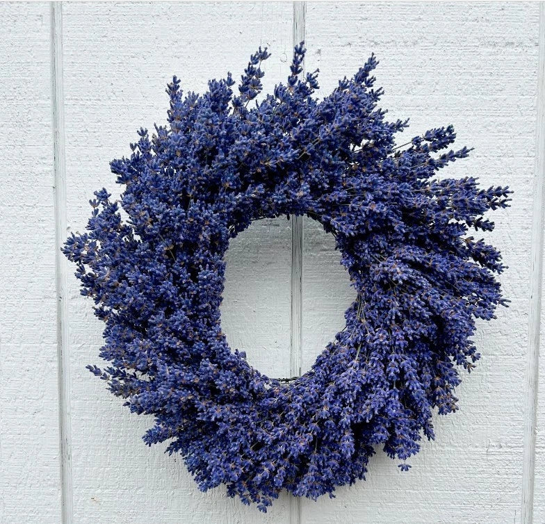 Lavender dried flower wreath with dense blue-purple blossoms, indoor decor.
