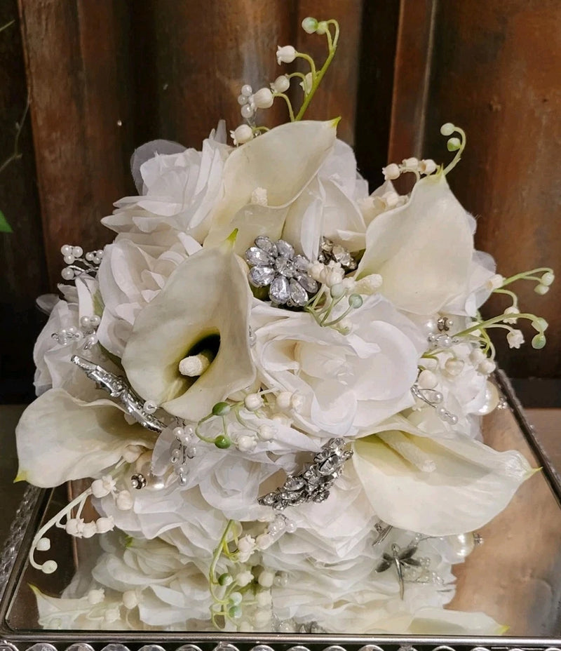 White silk flower bridal bouquet with silver brooch accents and small green buds