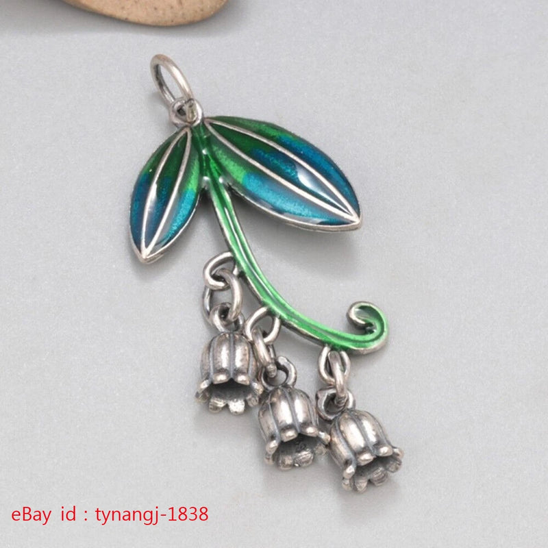 Sterling silver leaf-and-lily pendant with green and blue enamel, dangling charm drops
