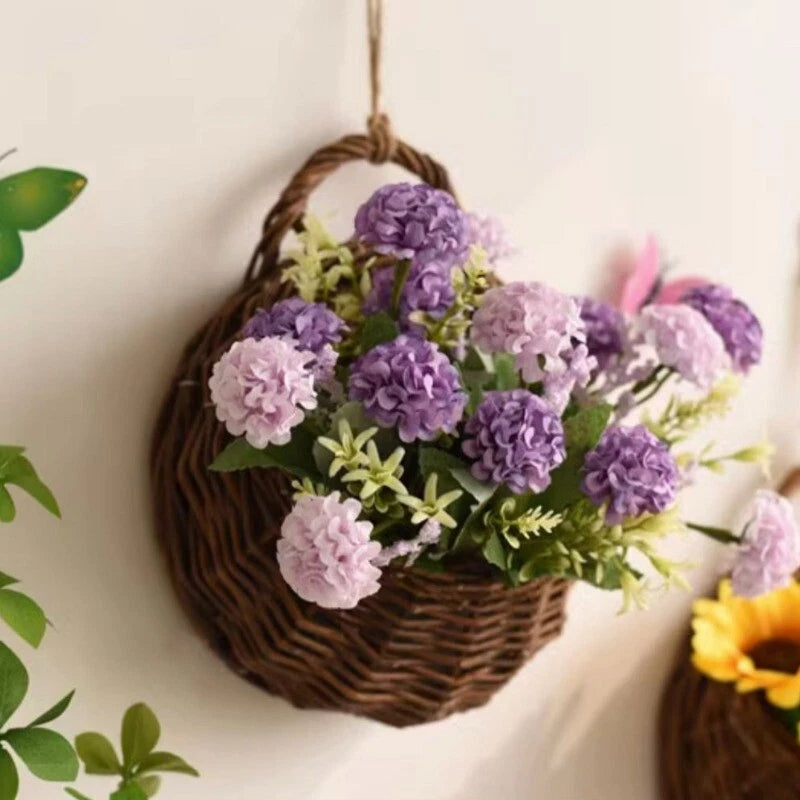 Woven flower planter wall hanging basket with purple and pink faux blossoms, hanging loop