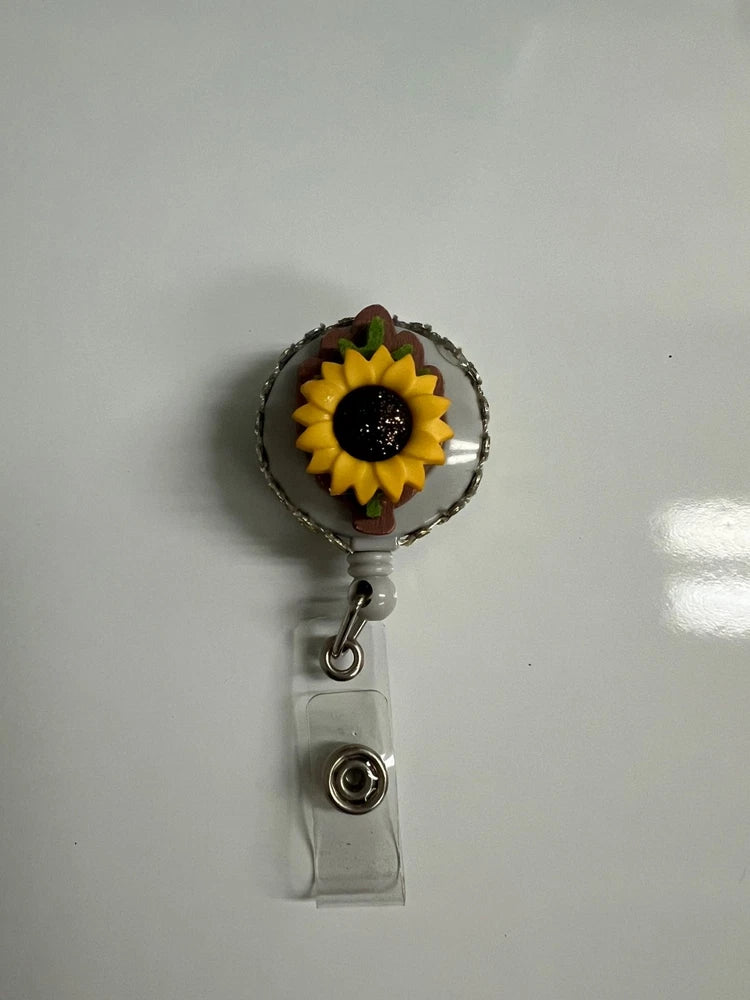 Retractable ID badge holder with sunflower charm and clear badge reel clip