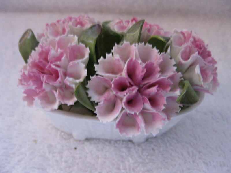White ceramic vase filled with pink carnations flowers
