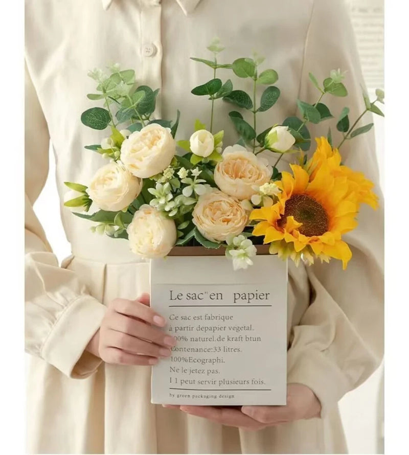Faux sunflower and rose bouquet with yellow sunflower and cream white roses held in hands