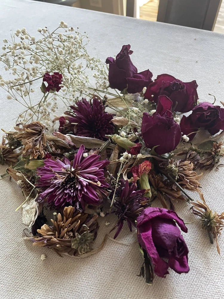 Dried flower bundle with maroon roses, purple blooms, white sprigs, and dried grasses