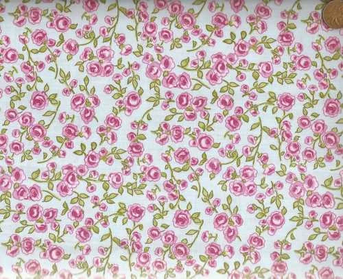 Floral cotton fabric with pink roses and green vines on a light background