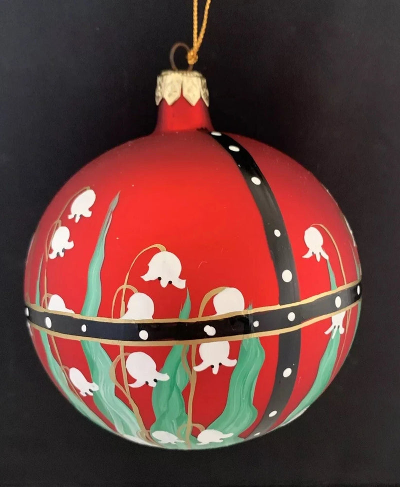 Red blown glass Christmas ornament with lilies of the valley and green stems, gold hanging loop