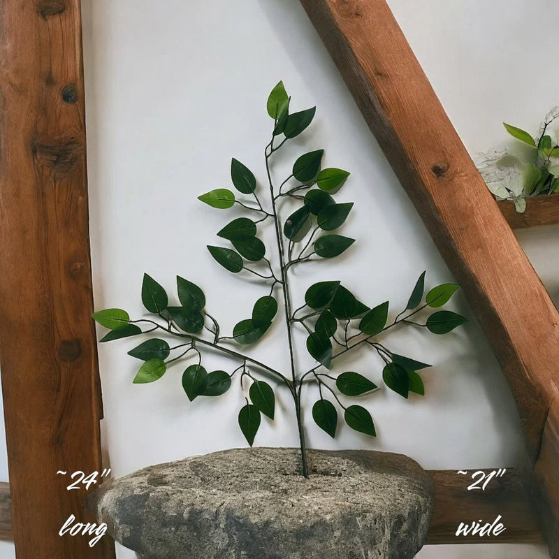 Artificial ficus greenery plant with green silk leaves on slender stems in gray pot