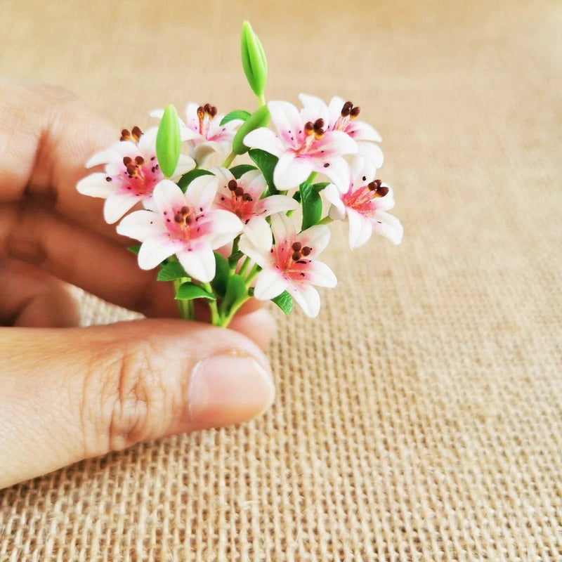 Miniature white lily bouquet with pink speckled centers and green buds