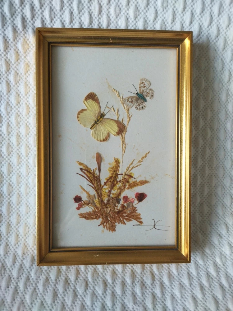 Gold-framed pressed flower and butterfly wall art with dried botanicals
