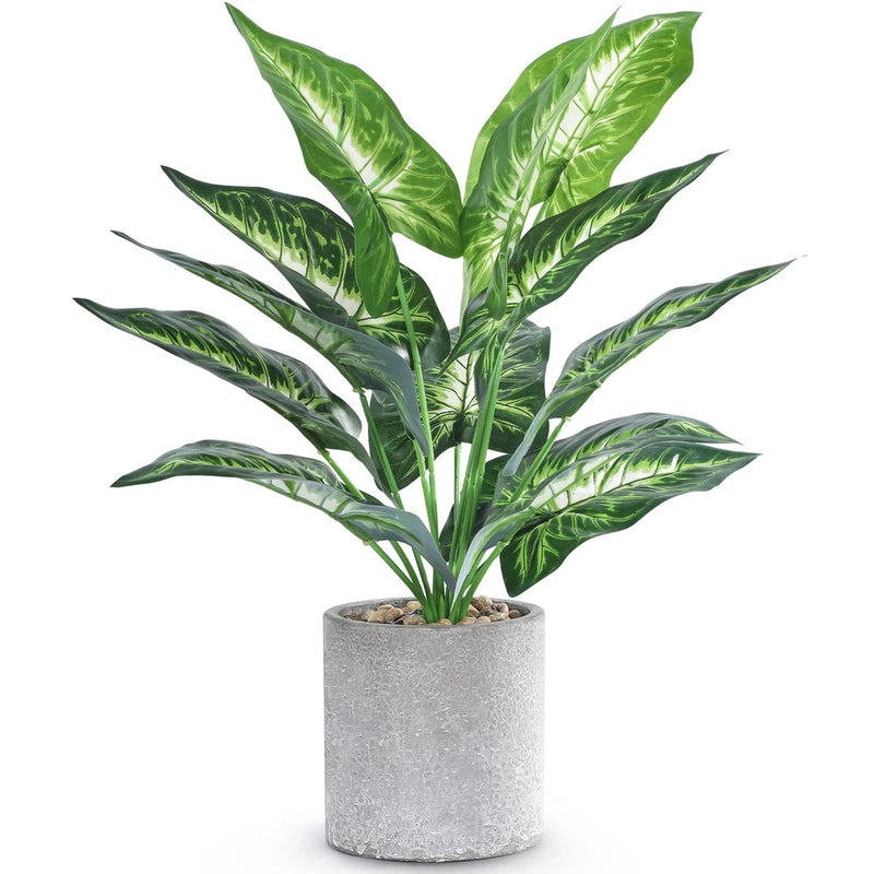 Small artificial tropical plant with green faux leaves in a gray concrete-style pot