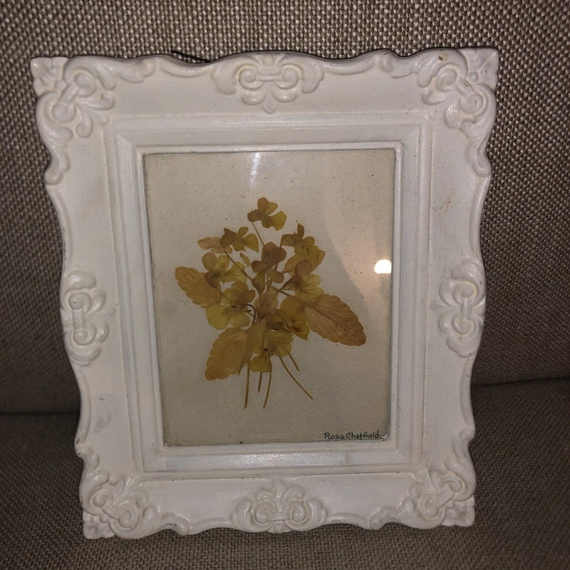 Signed pressed dried flowers in ornate white frame, bouquet with visible signature