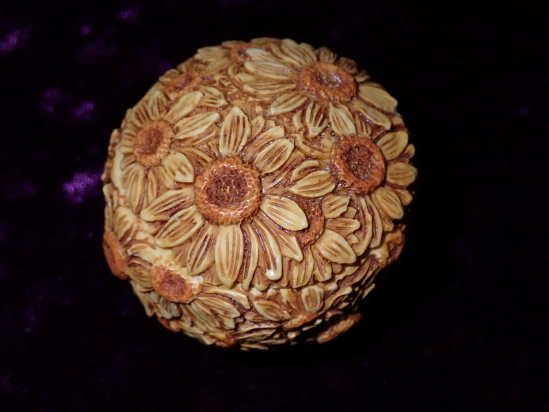Round decorative pot topper with sunflower petal and center detail, textured resin look