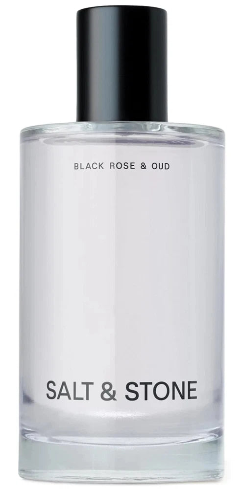 Body mist bottle with black cap, clear glass, labeled Black Rose & Oud, Salt & Stone