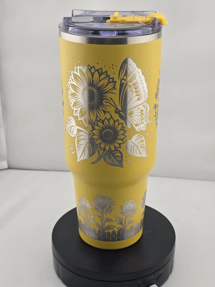 Yellow 40oz tumbler with laser-engraved sunflowers and butterflies, clear lid and straw top
