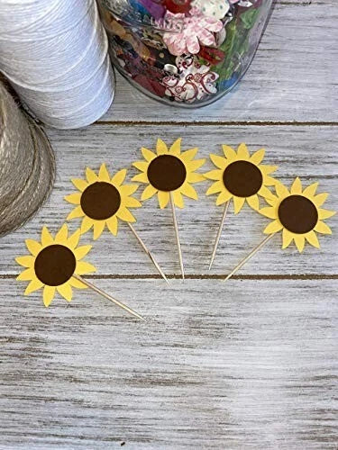Sunflower cupcake toppers: yellow daisy-like flowers with brown centers on wooden picks