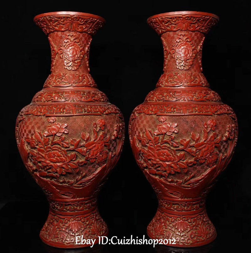 Pair of red lacquer peony vases, embossed floral relief and rounded bottle shape.