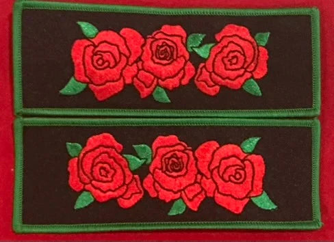 Embroidered rose cuff set with red roses and green leaves on dark fabric