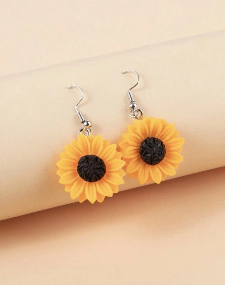 Sunflower resin drop earrings with yellow petals, dark centers, and silver fishhook dangles
