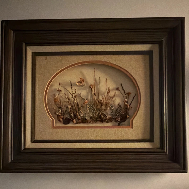 Framed dried flower wall art with arched botanical arrangement in a dark wooden frame