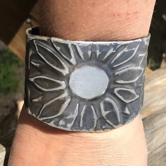Sterling silver cuff bracelet with embossed sunflower design, wide band