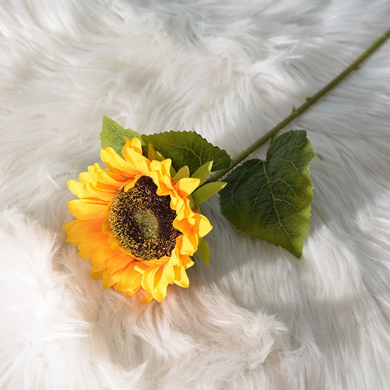Artificial sunflower stem with yellow petals, dark center, and green leaves