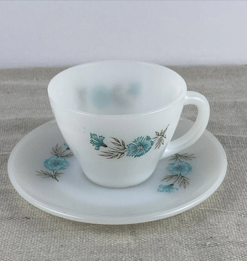 Vintage white tea cup and saucer with blue floral pattern and curved handle