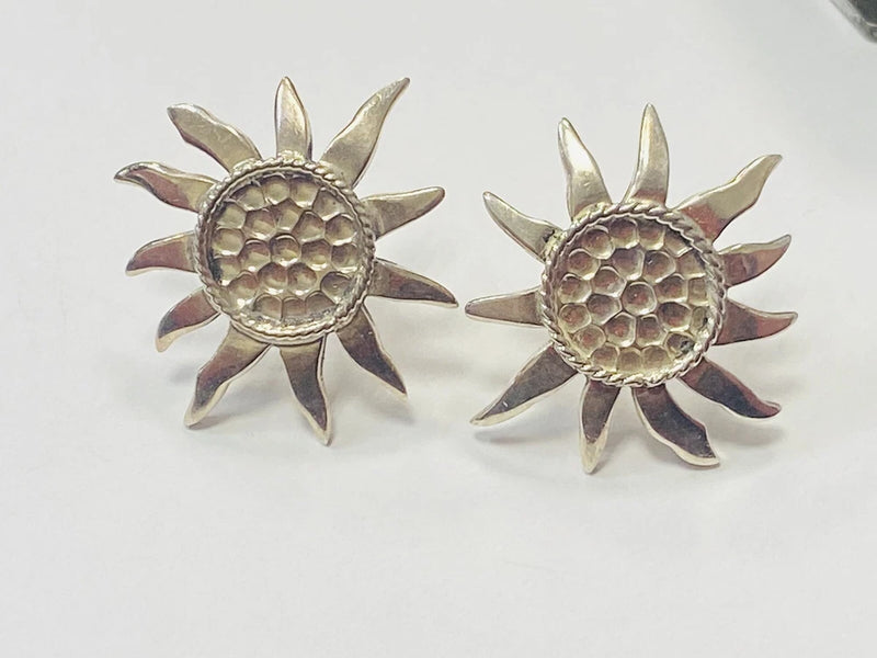 Sterling silver sunflower stud earrings with textured round centers and petal details