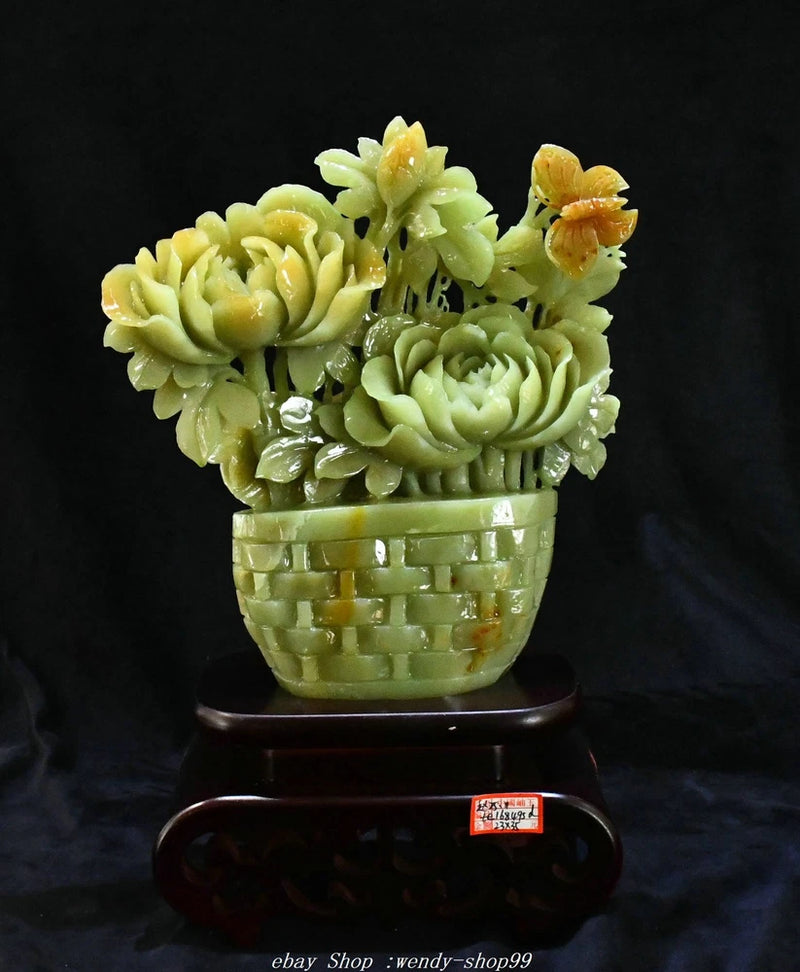 Carved green jade peony flower statue in basket base, on dark wooden stand