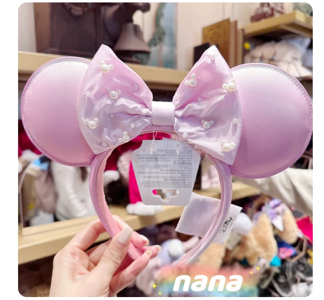 Light pink satin bow headband with large mouse-style ears and pearl accents