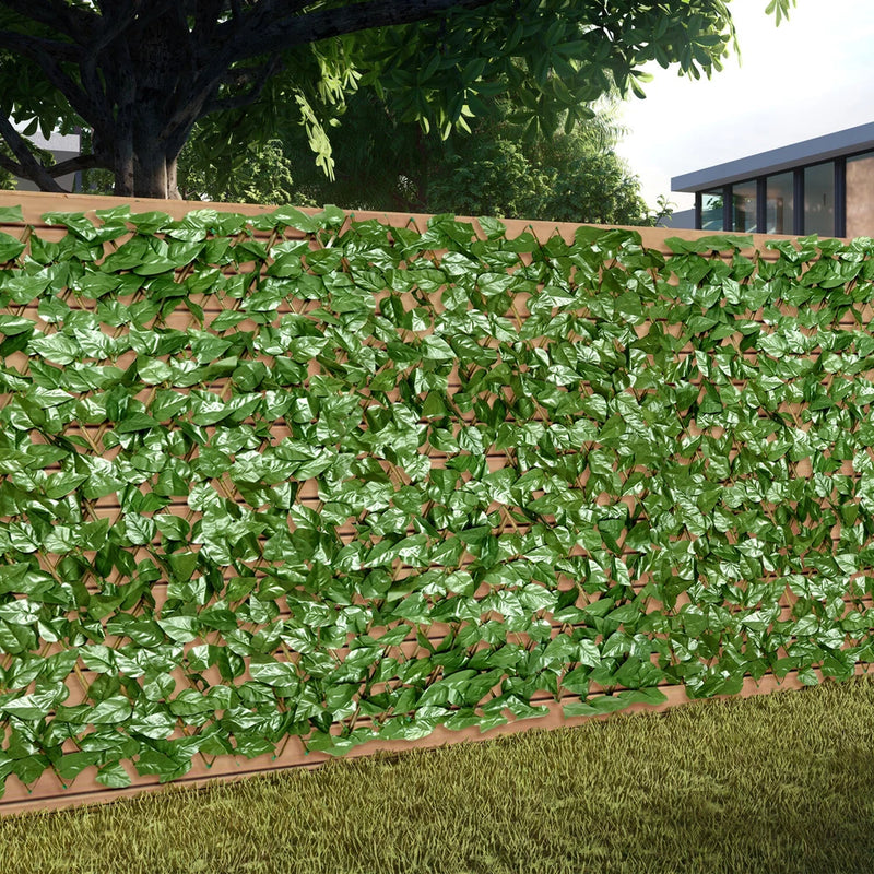 Artificial expandable faux laurel leaves fence panel with dense green foliage