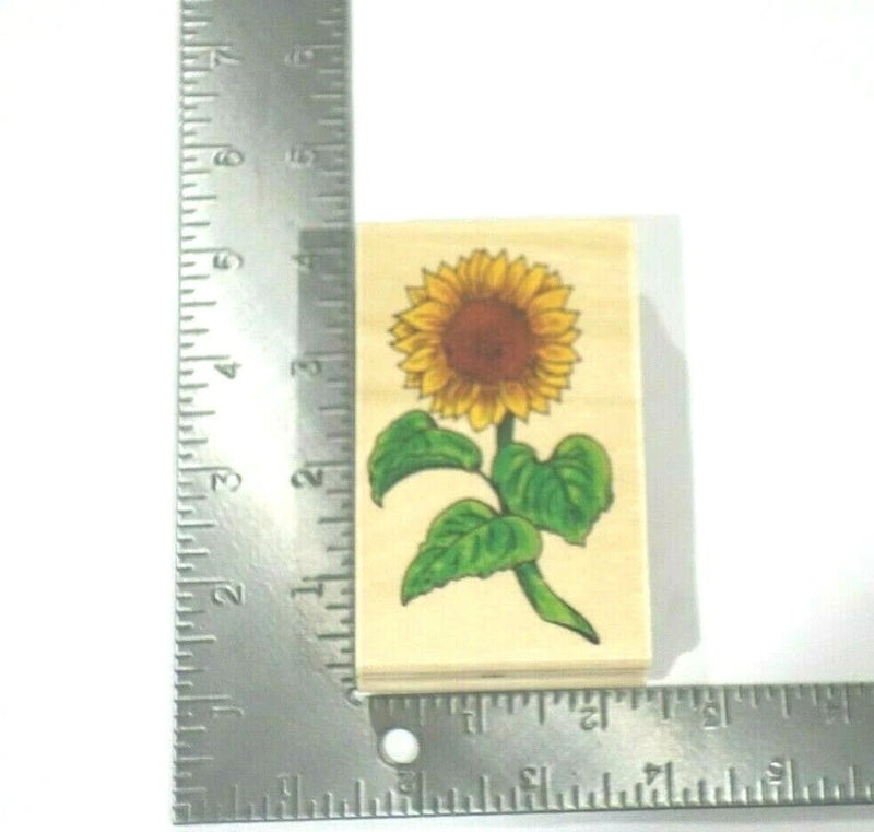 Small sunflower rubber stamp with yellow petals and green leaves on light backing