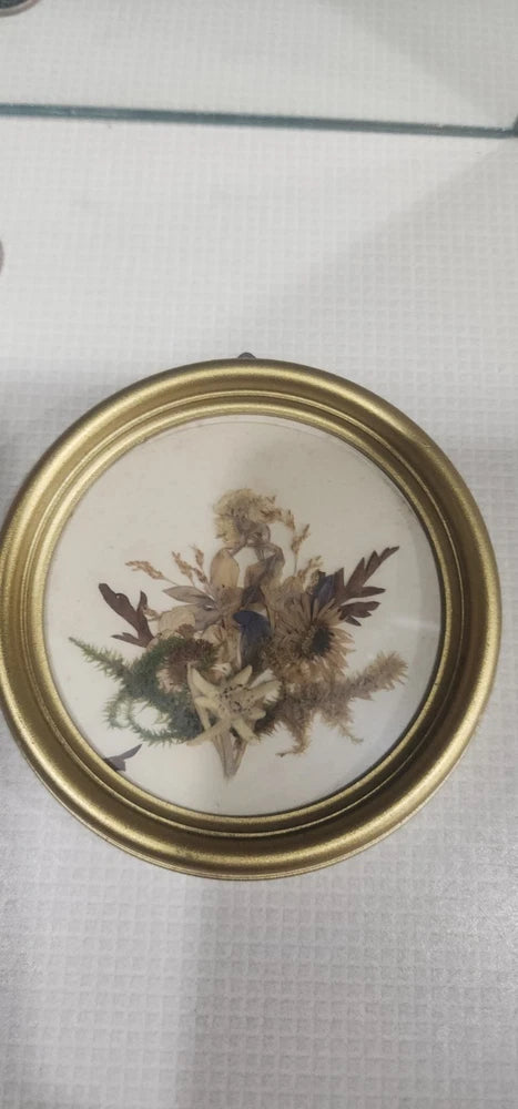 Gold circular framed pressed flowers artwork with dried floral bouquet centerpiece