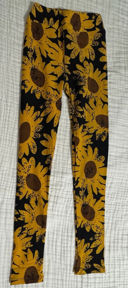 Kids sunflower leggings in yellow with black floral print, full-length