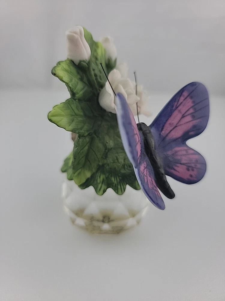 Porcelain butterfly ornament on crystal ball with lily blossom and green leaves