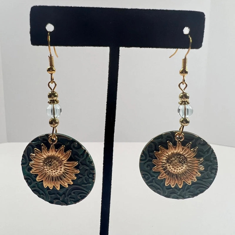 Gold-tone dangle earrings with round textured sunflower discs on hook backs