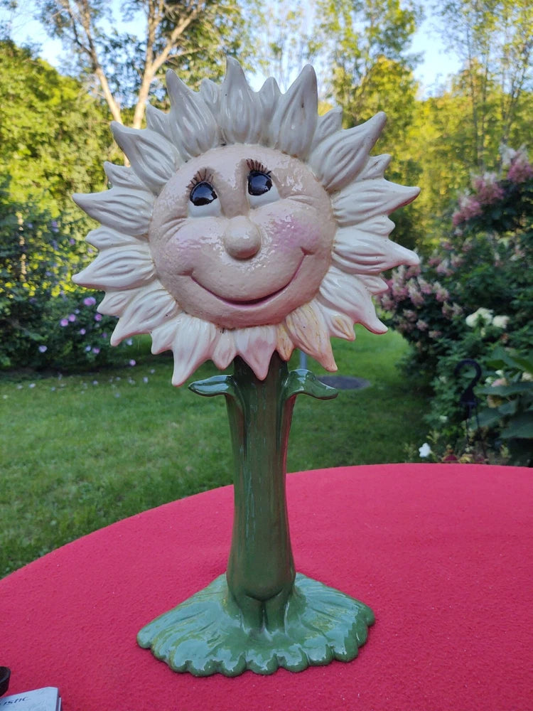 Smiling ceramic sunflower garden decor with white petals, rosy face, and green stem