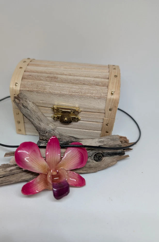 Pink dendrobium orchid in resin with black faux leather necklace, small wooden chest