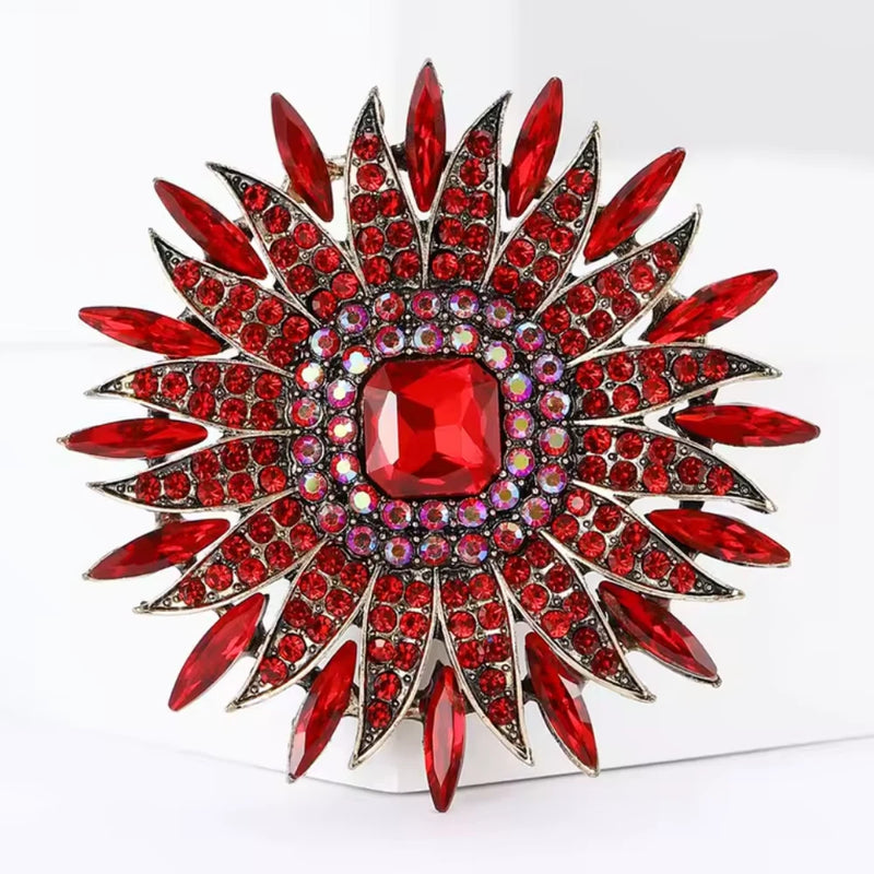 Rhinestone sunflower brooch pin with red crystals and gold-tone metal flower design