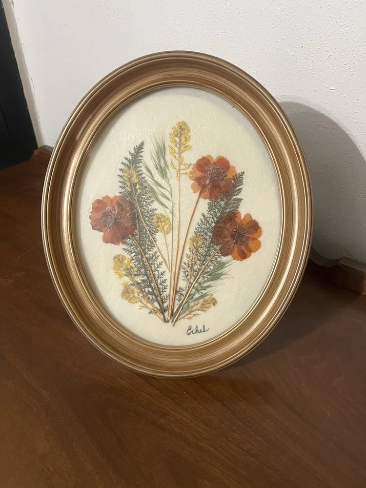 Oval wood frame pressed dried flower art with orange and yellow blooms