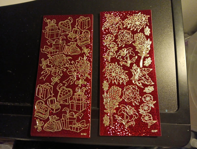 Red holographic gift and rose stickers set with gold foil designs on two sheets
