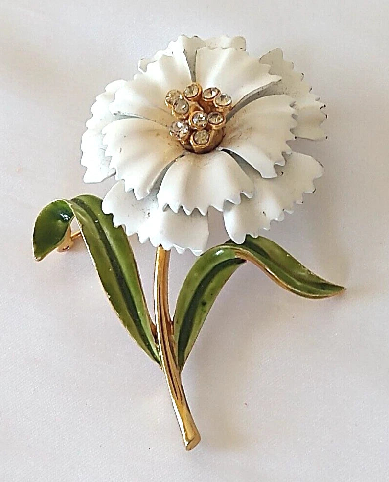 Vintage white enamel carnation flower brooch with green leaves and rhinestone center, gold-tone pin