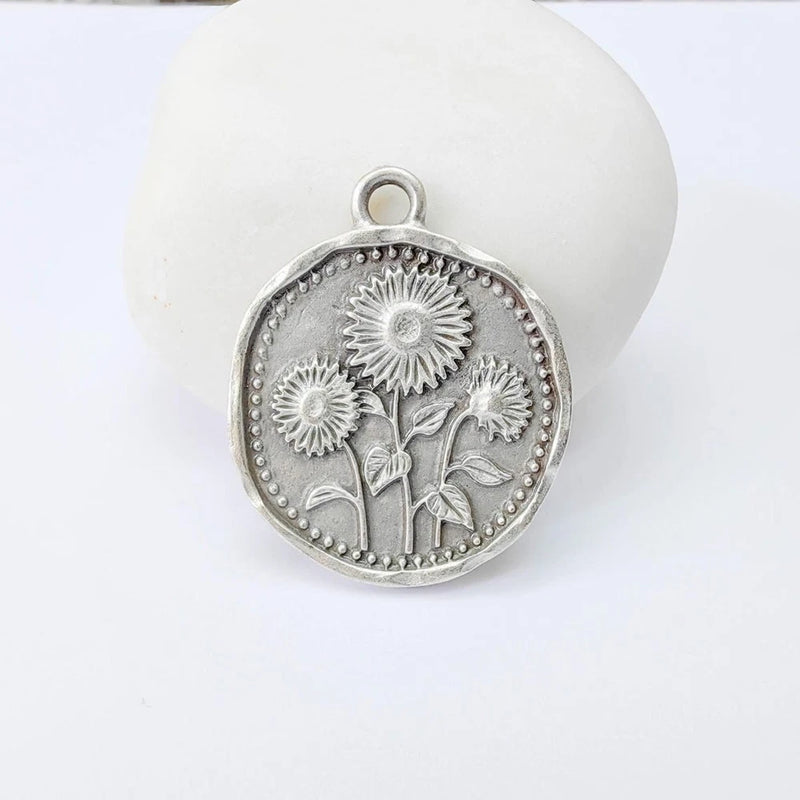 Antique silver sunflower charm pendant with top loop and engraved floral border
