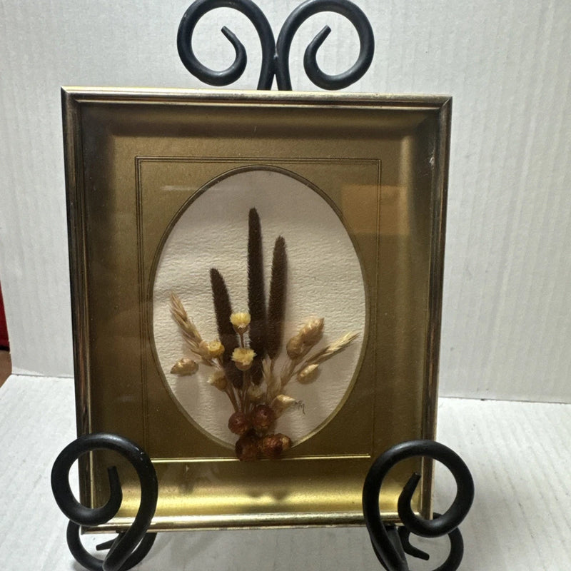 Vintage framed oval dried flower arrangement with dark stems in gold-tone holder