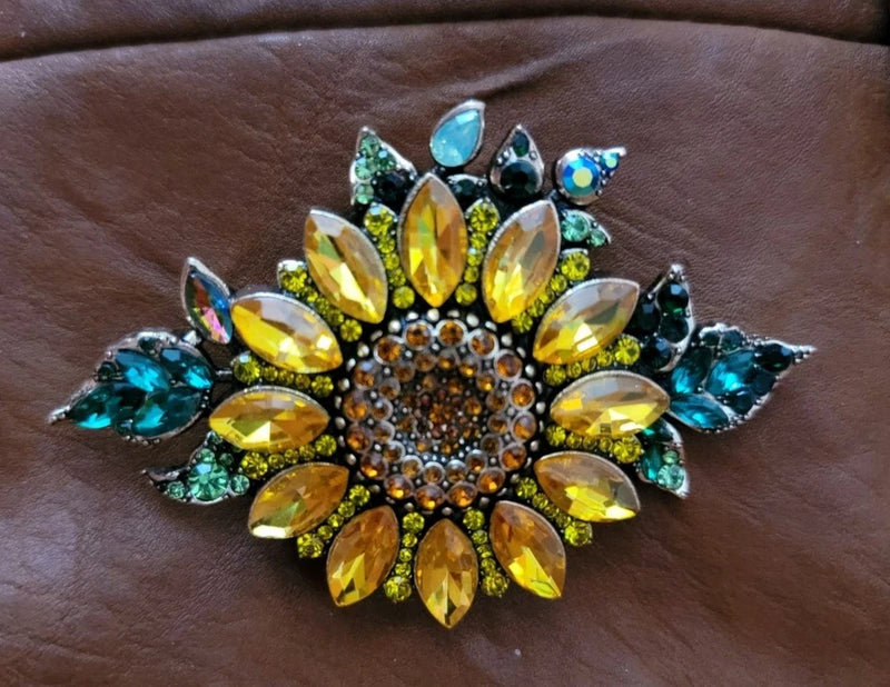 Sunflower rhinestone brooch with yellow and teal crystals, oval gems, and leaf accents