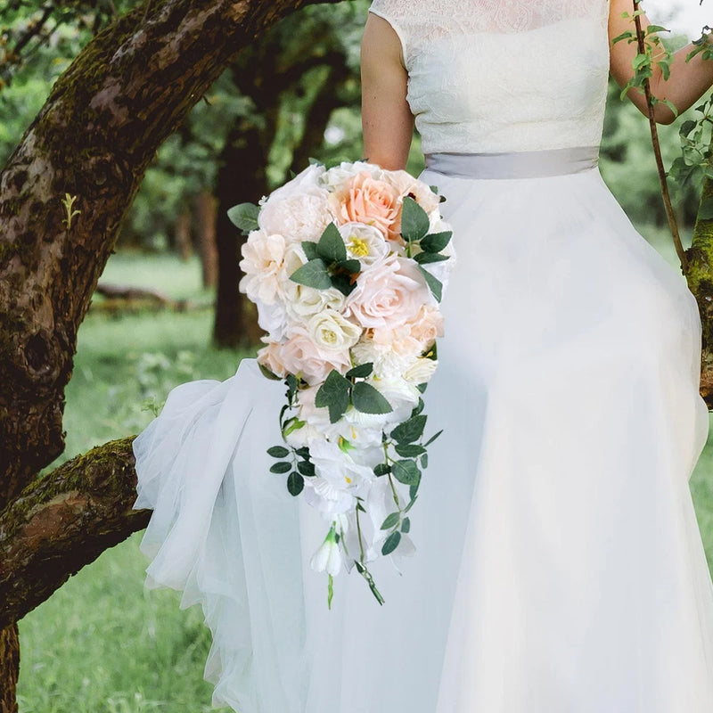 Cascading faux bridal bouquet with white and peach flowers, green leaves, and trailing stems