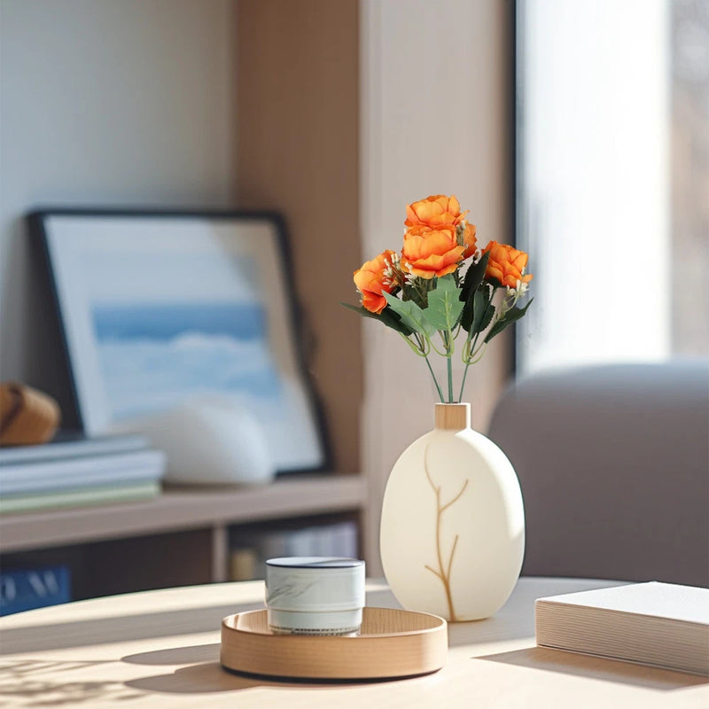 Artificial orange peonies in a white vase on a round tray
