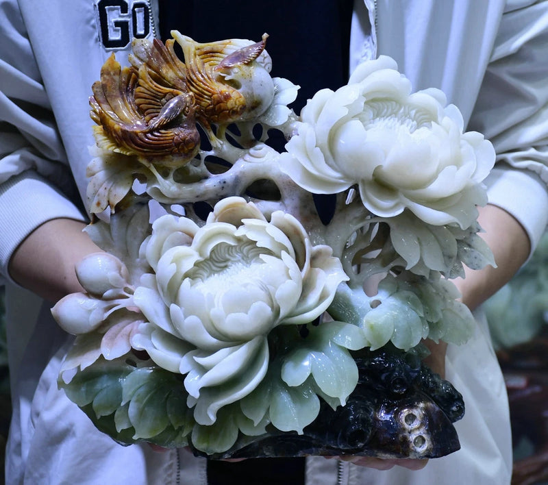 Carved jade peony and bird sculpture with white flowers and green leaves on dark base